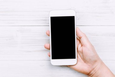 Kadın el Smartphone ahşap arka plan üzerinde tutarak