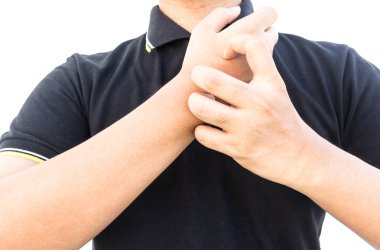 Alerjik deri üzerinde beyaz arka plan izole tırmalamak adam