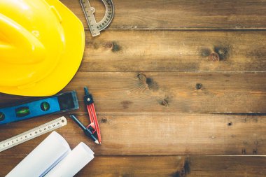 İnşaat araçları ile kask Emanet ahşap arka plan üzerinde