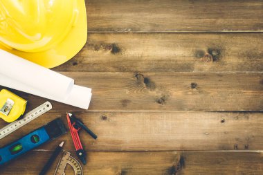 İnşaat araçları ile kask Emanet ahşap arka plan üzerinde