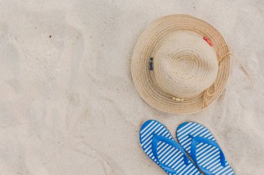 Hasır şapka ve tropikal bir plajda flip flop