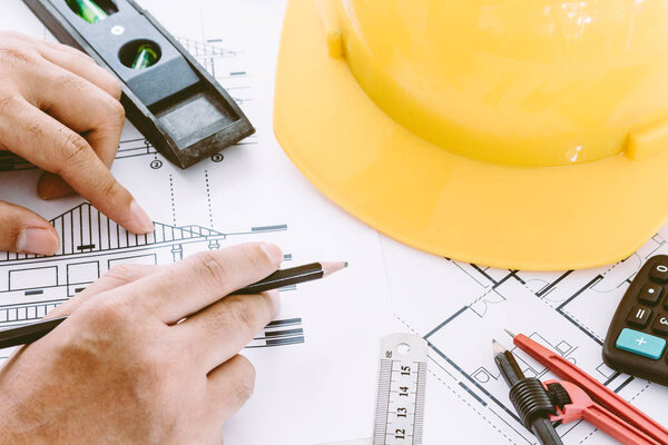 Architect working with construction tools and helmet safety on wooden background