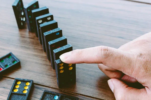 Hands playing domino on wooden table