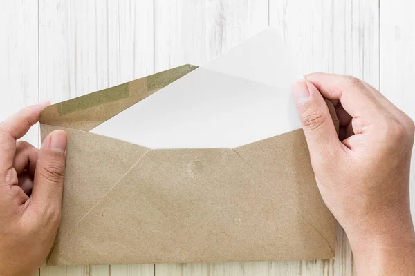 Hand Houden Een Enveloppe Papier Houten Achtergrond — Stockfoto