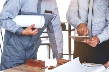 Takım mühendis inşaat araçları ile masada çalışıyor