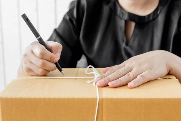 Mujer Firma Papeles Entre Paquetes — Foto de Stock