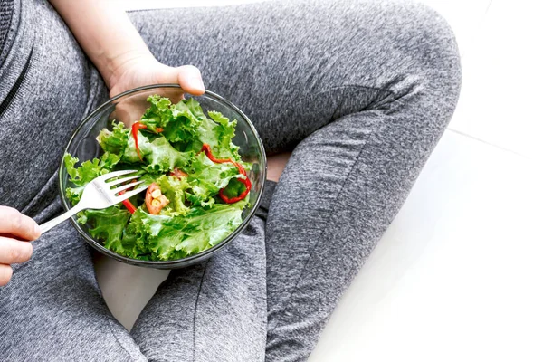 Fit healthy woman eating a fresh salad