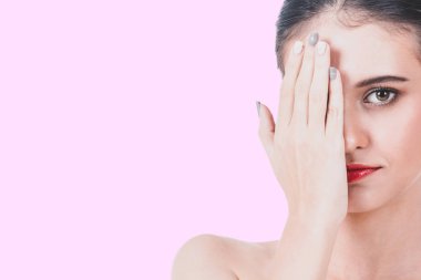 Kadın portresi pembe bir arka plan üzerinde elleriyle gözlerini kapatır