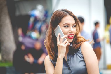 Sokakta smartphone kullanan genç kadın portresi