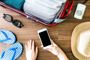 Kadın el Smartphone açık traveler's çanta ile tutarak