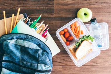Öğle yemeği kutusu, ahşap masa bir sağlıklı okul öğle yemeği için ekmek ve sebze ile