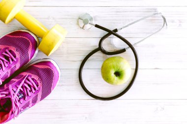 Steteskop ve ahşap arka plan - sağlıklı kavramı üzerinde spor ayakkabı 