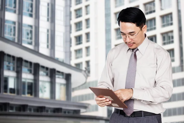 Businessman use tablet on blur office building background