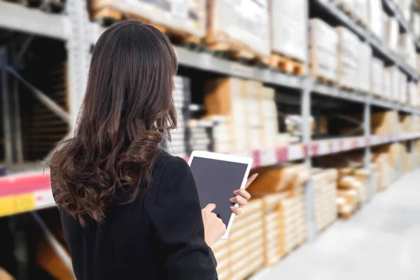 Businesswoman checking list order on a warehouse