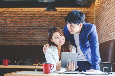 Genç çift kahve dükkanında tablet bilgisayar kullanarak