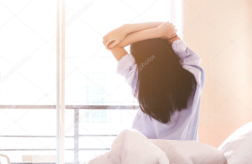 Woman stretching in bed after wake up