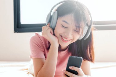 Kadın yatakta kulaklık ile müzik dinleme