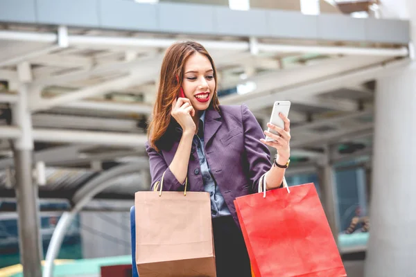 Alışveriş çantası sokakta yürürken tutan kadın