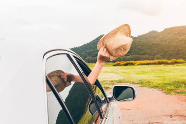 Kadın el araba rahatlatıcı ve mutlu traveler dağ arka plan üzerinde şapka tutarak