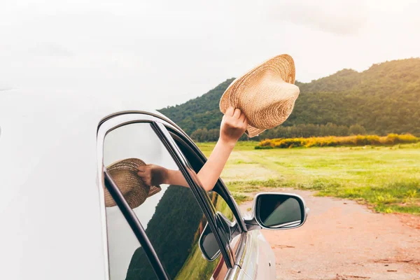 Kadın el araba rahatlatıcı ve mutlu traveler dağ arka plan üzerinde şapka tutarak