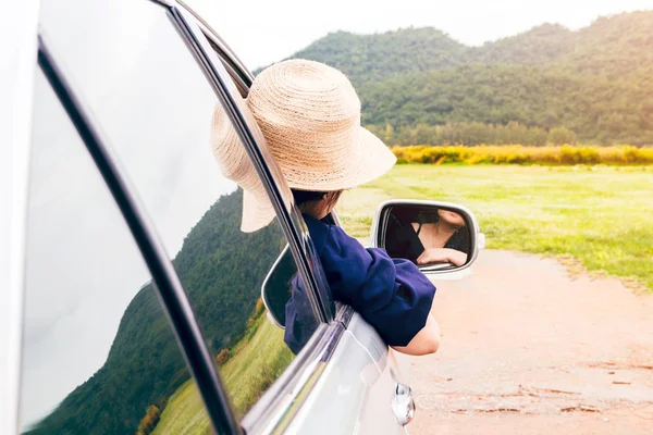 Kadın dağ arka plan ile arabada pencereden rahatlatıcı
