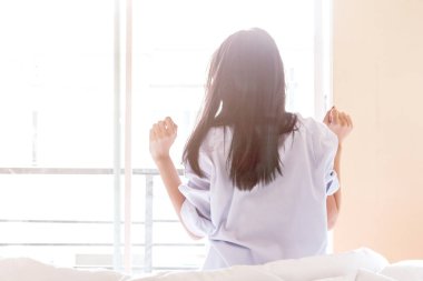 Kadın uyandıktan sonra yatakta geriniyor.