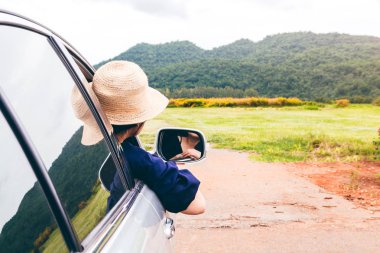 Kadın dağ arka plan ile arabada pencereden rahatlatıcı