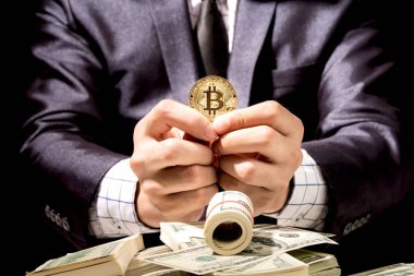 Bitcoin siyah arka planda tutan işadamı