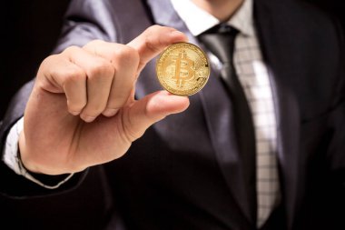 Bitcoin siyah arka planda tutan işadamı