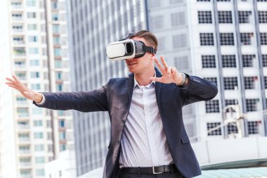 Genç adam sanal gerçeklik gözlükleriyle eğleniyor.