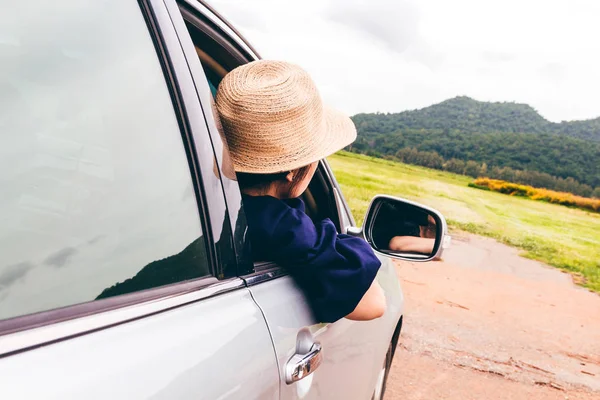 Kadın dağ arka plan ile arabada pencereden rahatlatıcı