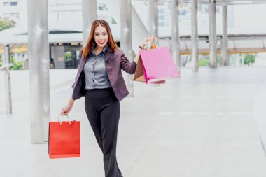 Alışveriş çantası sokakta yürürken tutan kadın