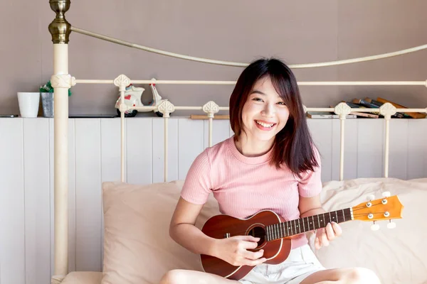 ベッドで ギターを弾く女性 — ストック写真