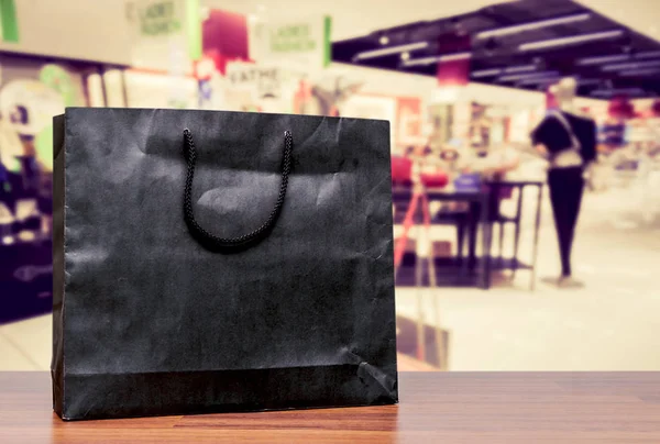 Черный Пакет Покупок Деревянном Столе Фоном Магазина — стоковое фото
