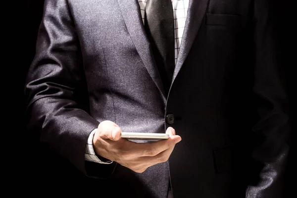 Geschäftsmann Eleganten Schwarzen Anzug Mit Smartphone Auf Schwarzem Hintergrund — Stockfoto