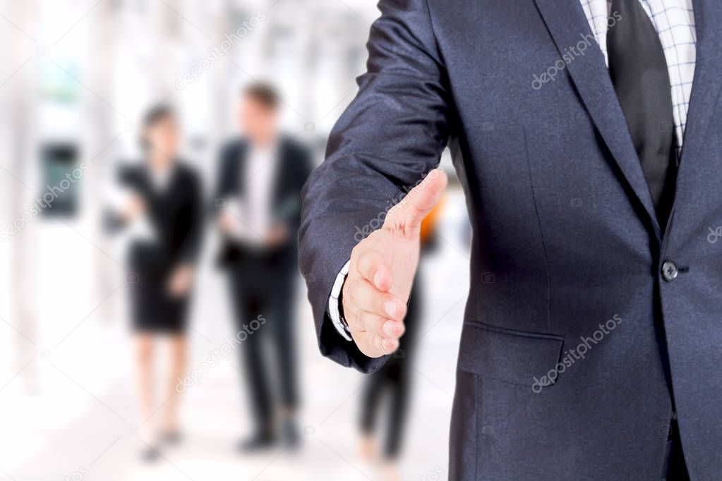 Businessman offering handshake on group of business  background