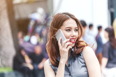 Sokakta smartphone kullanan genç kadın portresi