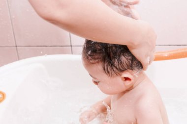 Annesi banyoda bebek baş şampuanla yıkama