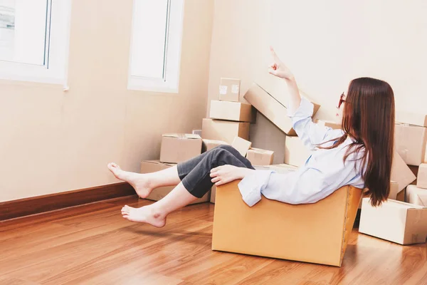 自宅に段ボール箱に座っている若い女性 — ストック写真