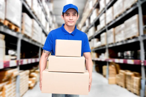 Deliveryman Holding Kartong Lager Suddig Bakgrund — Stockfoto