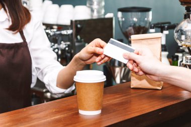 Kadın barista müşteri kafede kredi kartı alarak