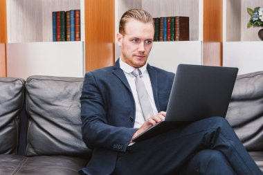 Dizüstü bilgisayar ve işletme belgesi üzerinde ofiste çalışan iş adamı