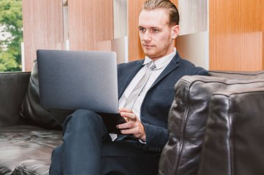 Dizüstü bilgisayar ve işletme belgesi üzerinde ofiste çalışan iş adamı