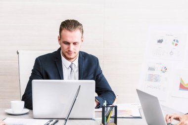 Dizüstü bilgisayar ve işletme belgesi üzerinde ofiste çalışan işadamı Yöneticisi