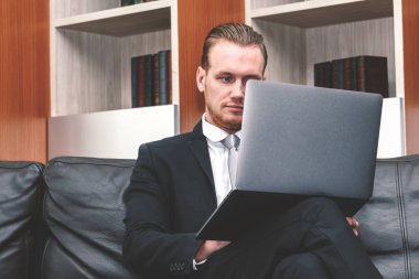 dizüstü bilgisayar ile ofiste çalışan iş adamı