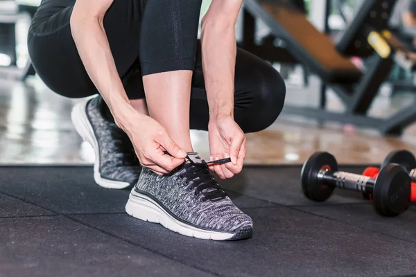 Kadın Spor Salonunda Fitness Ekipmanları Ile Onun Ayakkabı Bağcığı Bağlama — Stok fotoğraf