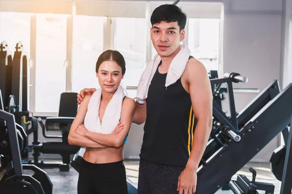 Sport man and woman with towel stand at the gym.fitness and lifestyle concept