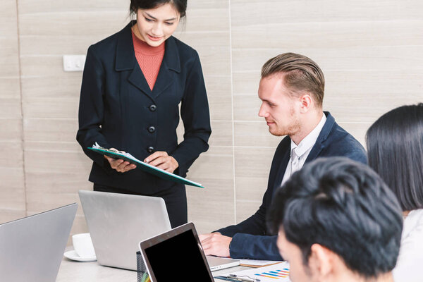 Businesspeople using laptops and discussing together in meeting room.Teamwork concept