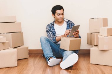 Genç adam evde - karton kutu ile iş online ve teslimat kavramı