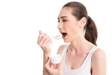 Genç kadın beyaz arka plan üzerinde izole yoğurt yeme